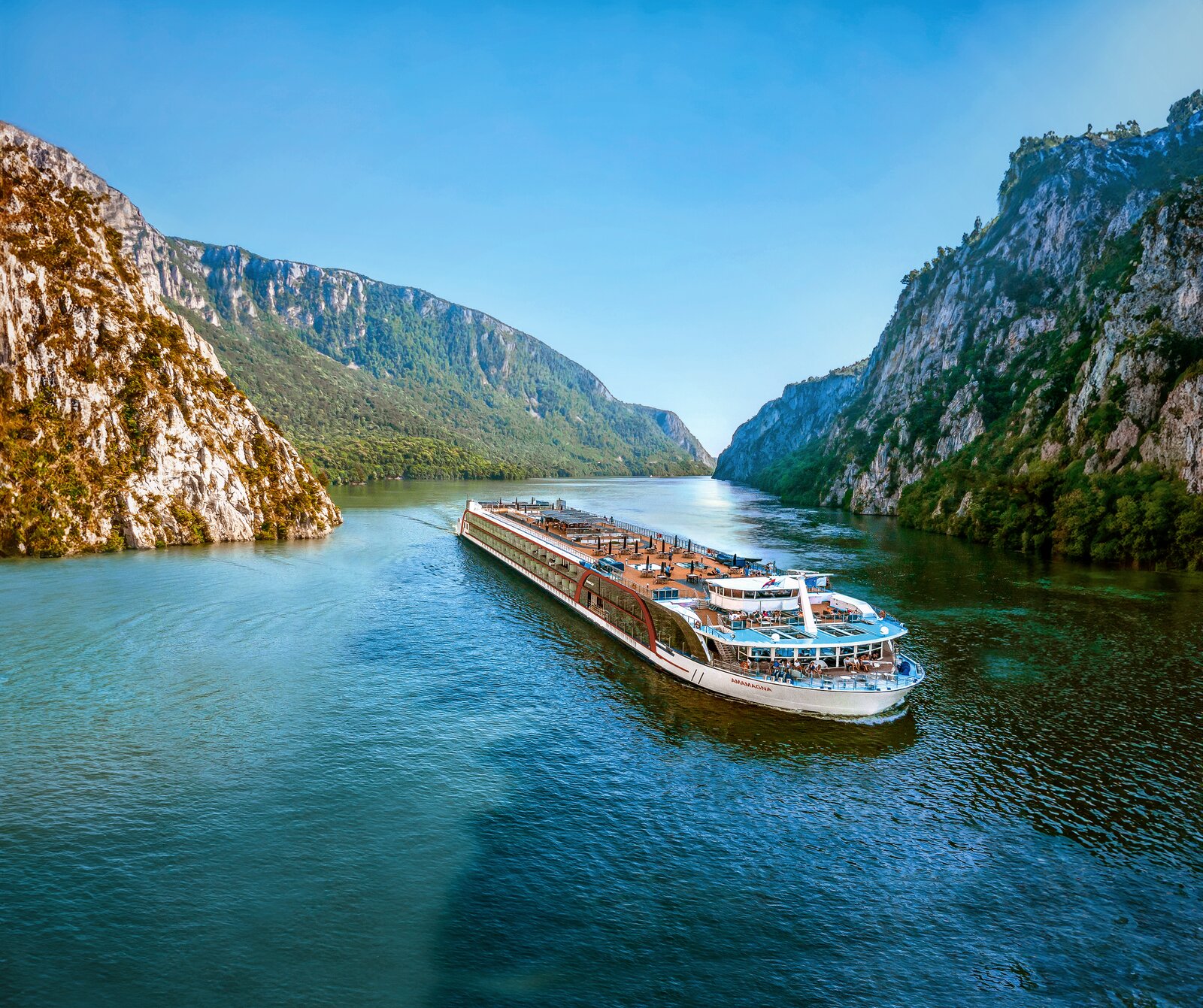 AmaWaterways’ AmaMagna river cruise ship sailing between cliffs on the Danube